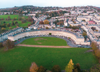 Fototapeta na wymiar The Royal Crescent in Bath city skyline with a sunset sky in autumn. Leaves brown color in England UK. Arial photography with drones.