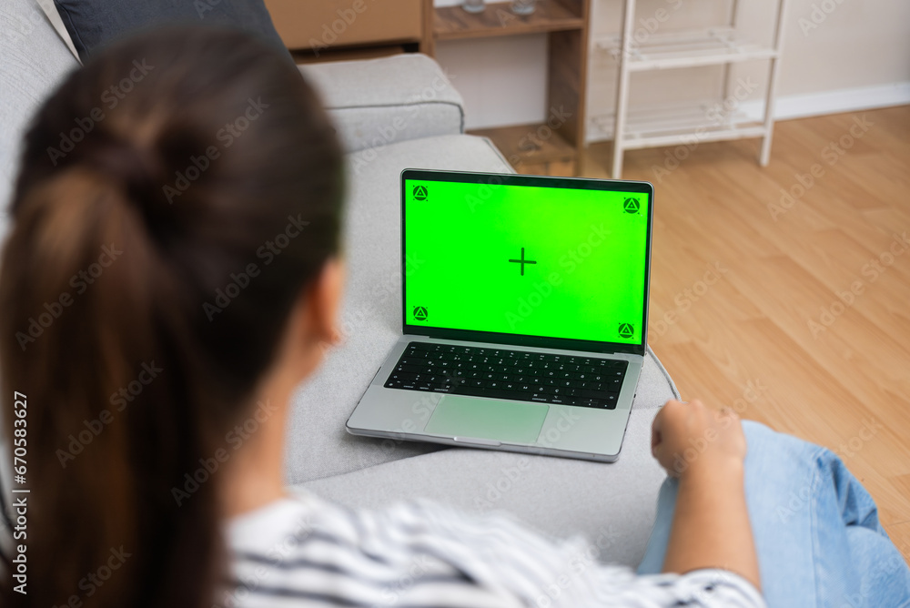 Poster woman works on computer sitting on sofa closeup female freelancer works at home looking at screen wi