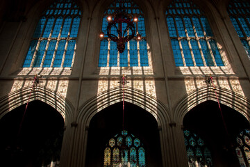 Fototapeta na wymiar Inside of the Bath Abbey with gothic architectural style. Famous cathedral in England. High church windows with lights and shadows. Christian chapel interior building in United Kingdom