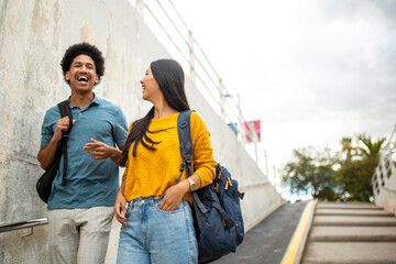 Obraz premium happy male and female students with bag walking on street