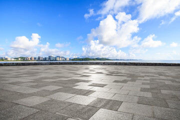 Empty square floors and city skyline by the sea