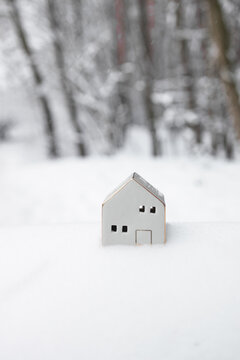 Merry Christmas and 2024 happy new year horizontal banner with small toy model house on winter snow background. Miniature white toy house model. High quality photo