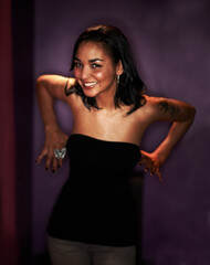 Fototapeta premium Woman, smile and happy in portrait at nightclub, energy and excited by wall. Mexican female person, positive and crazy at event, party and fun or fashion, cool and trendy or stylish clothing in dark