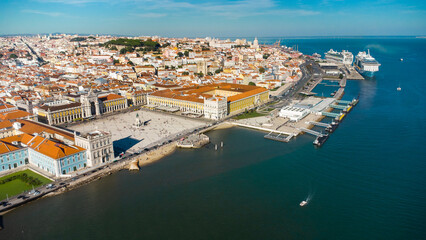 Fototapeta premium Aerial drone point of view of Commercio Square, Downtown Lisbon, Portugal. Panoramic view of cold city center. Travel destination visited annually by many foreigner tourists. Sunset colours 