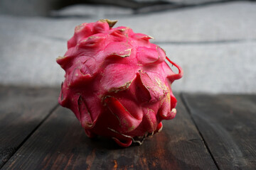 Red dragon fruit on a wooden table. Red Dragon Fruit is also known as Pink Pitaya or Strawberry...