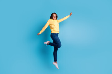 Carefree woman jumping against blue background