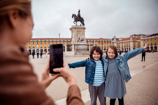 Two children posing for a photo in a historic square