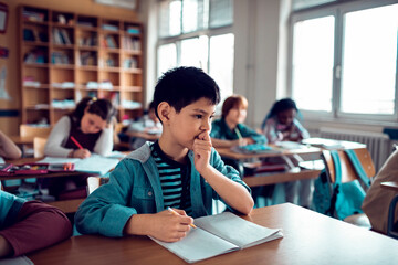 Thoughtful young boy in a classroom setting