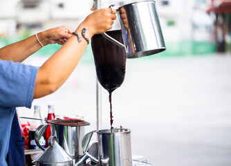 Thai woman make a cup of coffee is a traditional.