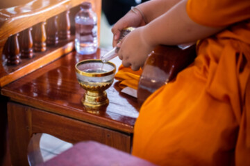 ฺฺBlurry picture of the ceremony of pouring water into the alms bowl and praying in Buddhism. Monks performing Buddhist ceremonies.