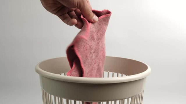 The old rag is thrown into the trash for recycling or disposal.