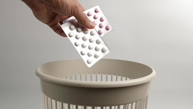 Expired vitamins in the form of tablets are thrown into the trash for recycling or disposal.