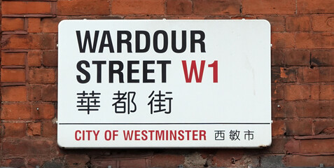Fototapeta na wymiar Closeup of Wardour Street sign in both English and Chinese on a brick wall in Westminster, London W1, UK. 