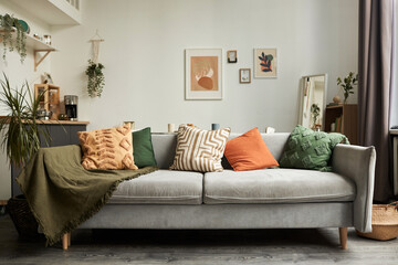 Background image of cozy home interior with focus on comfortable couch and textile decor , copy space