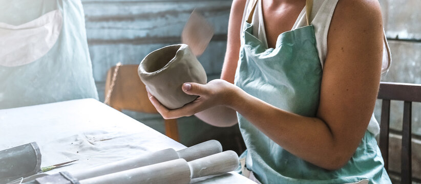 Potter Makes Dishes From Clay, Ceramics.Craft,work By Hand In The Workshop.Do It Yourself Products From Ceramics.Close Up Of Human Hands Making A Clay Bowl. Pottery Teaching Class