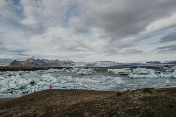 Woman in red jumper standing overlooking Jökulsárlón glacier lagoon in Iceland