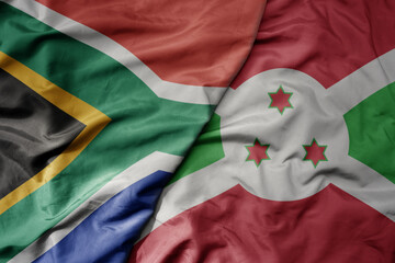 big waving national colorful flag of south africa and national flag of burundi .