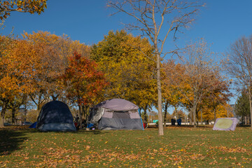 Homeless people shelter tents encampment in downtown city park in Toronto, Canada. Homelessness, inequality, injustice, poverty and social issues concept. - obrazy, fototapety, plakaty