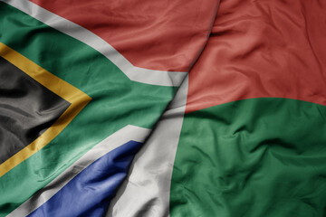 Obraz premium big waving national colorful flag of south africa and national flag of madagascar .
