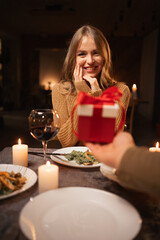 Romantic candlelight dinner for two, Valentine's Day date, man giving a gift to woman, romantic family relationship, Valentine's day celebration