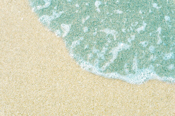 Background with emerald wave on white sand.
