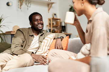 Portrait of young African American couple talking joyfully in morning in cozy home, everyday life - obrazy, fototapety, plakaty