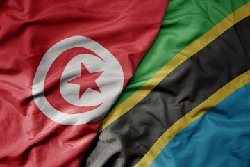 big waving national colorful flag of tunisia and national flag of tanzania .