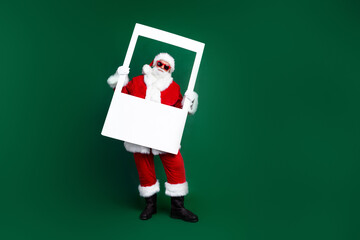 Full length photo of positive good mood santa dressed red costume taking new year photo empty space isolated green color background - Powered by Adobe