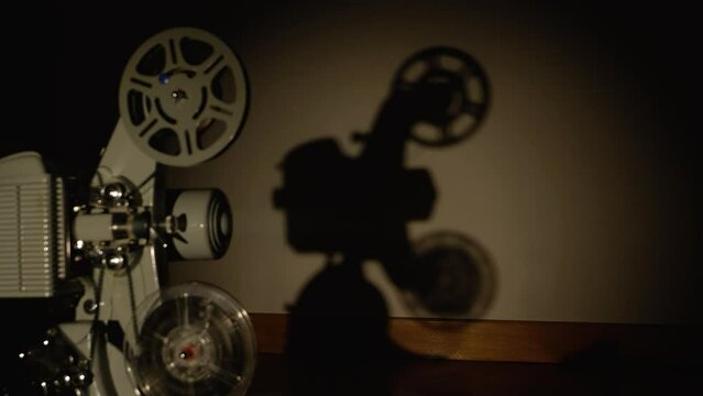 proiettore vintage in pellicola super 8mm in funzione con visuale prospettica della sua ombra