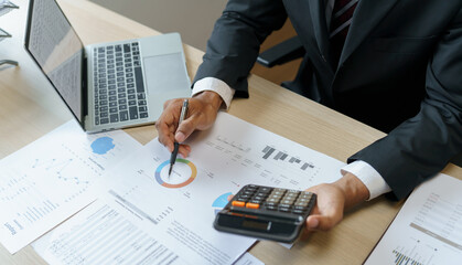 Businessman Accountant analyzing investment charts Invoice and pressing calculator buttons over...