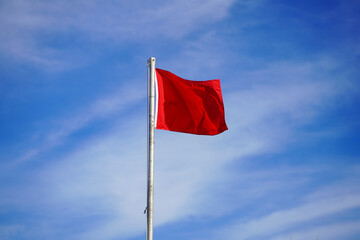 Red flag surf warning sign on beach