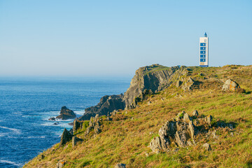 Fototapeta na wymiar Beautiful Atlantic Ocean Coast landscape with dangerous cliffs and a modern lighthouse on top of a promontory