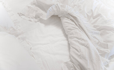Bed with blanket and pillows and white linen