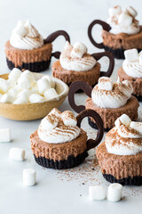 Mini cheesecakes shaped like cups of hot cocoa with marshmallows.