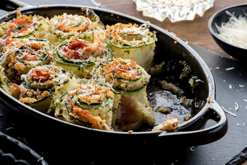 An appetizer of zucchini roll ups topped with parmesan cheese