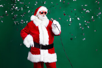 Photo of positive funky santa dressed red costume singing new year carols isolated green color...