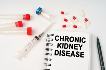 On the table are pills, injections, a syringe and a notepad with the inscription - chronic kidney disease