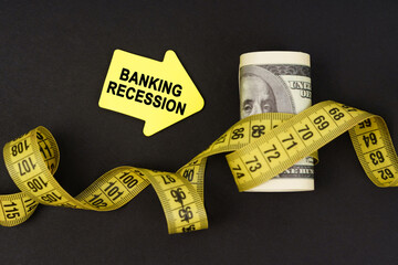On a black surface there are dollars wrapped in measuring tape and stickers with the inscription -...