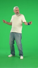 Portrait of senior man hipster on Chroma key green screen, man in white t-shirt dancing posing...