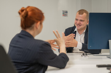 Business partners communicate in sign language. A deaf boss gives a task to a subordinate woman.