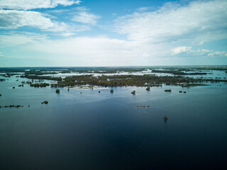 Flooded country roads and flooded meadow. Flight over a flooded country road in a beautiful meadow at sunset. Aerial view.