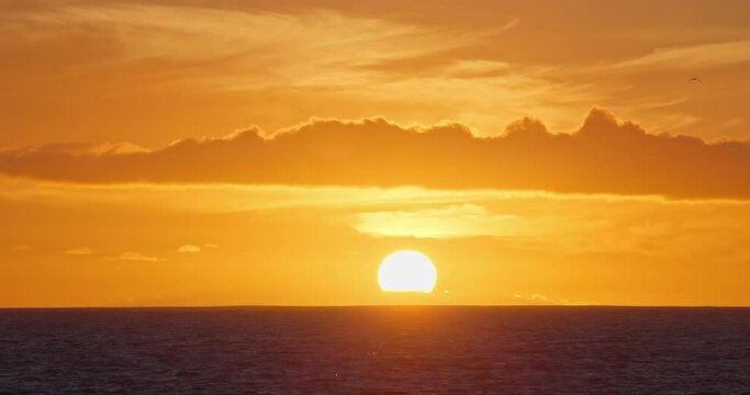 Sunset over ocean zoom in real time video, close up big sun setting horizon natur backgroung