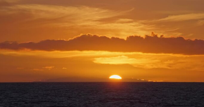 Sun setting down over ocean cinematic long real time video 4K. Beautiful nature landscape background, sunset evening dusk twilight sundown, open horizon orange red skies, scenic beauty golden hour.