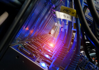 close up of network cables connected to server racks in data center room