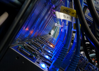 close up of network cables connected to server racks in data center room
