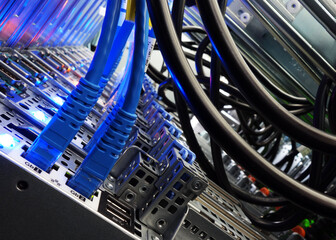 close up of network cables connected to server racks in data center room