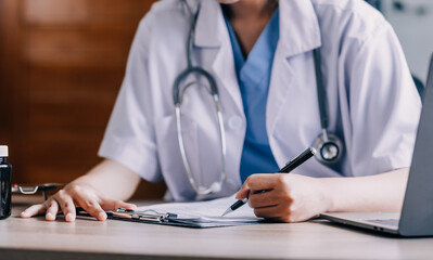 Medical doctor or physician consulting patient's health online using internet mobile digital tablet in clinic or hospital office for professional emergency healthcare assistance service concept