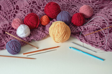 Fototapeta na wymiar Knitting. Balls of wool, knitted shawl, knitting needles and сrochet hooks. Copy space
