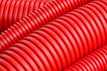 Close-up of flexible red hoses for laying power cables in the ground.