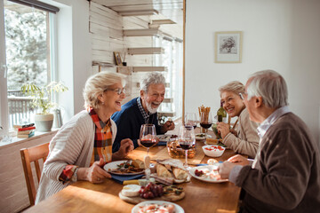 Elderly friends share laughter and stories over a delightful meal